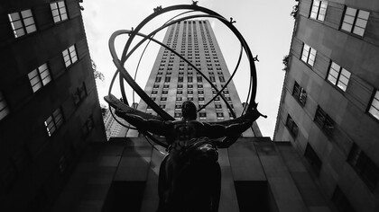 The Atlas sculpture at Rockefeller Center stands prominently between towering buildings, symbolizing strength and endurance, New York, USA