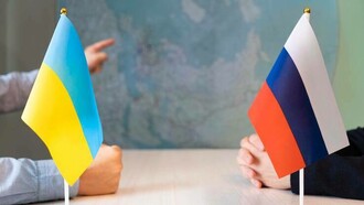 Ukrainian and Russian delegates sitting at a table negotiating a possible peacetalk 