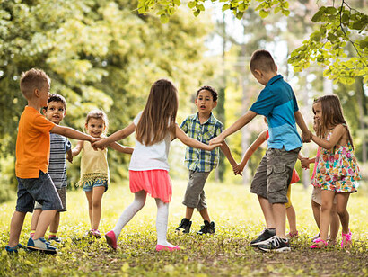 Niños de diversas edades cantan una ronda