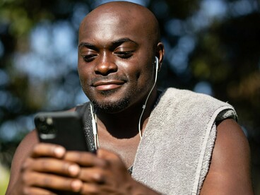 A man focused on his phone, reflecting how mobile technology has become an essential financial tool