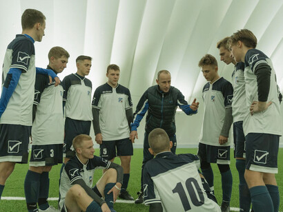 In the midst of a strategic discussion, the soccer team's huddle reflects the importance of dynamic leadership in driving performance and fostering unity