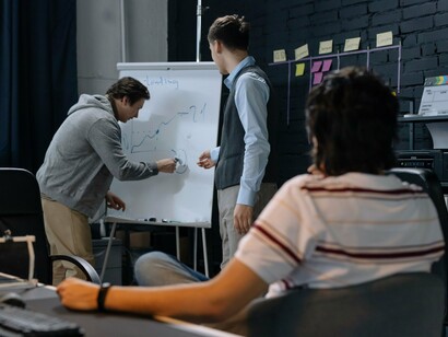 A startup team brainstorming around a whiteboard, representing rapid experimentation and continuous learning in lean innovation