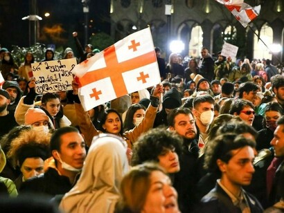 Protesters listen intently to a speaker during a rally in Georgia against a bill designed to limit the influence of ‘foreign agents’