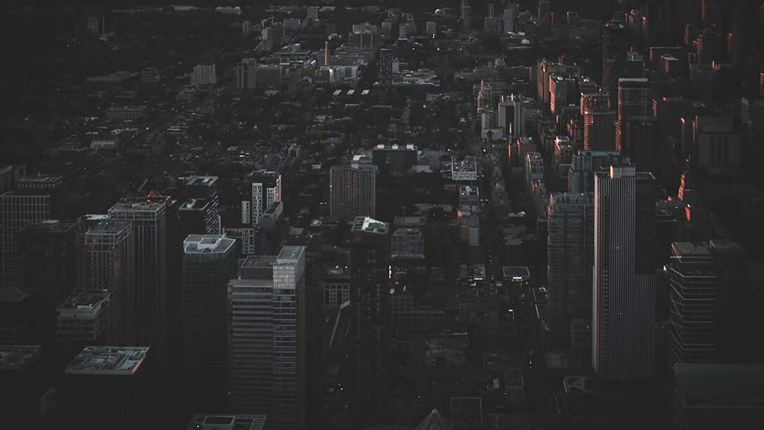 An aerial view of the city at night reveals a rare silence—its streets darkened by a widespread power outage