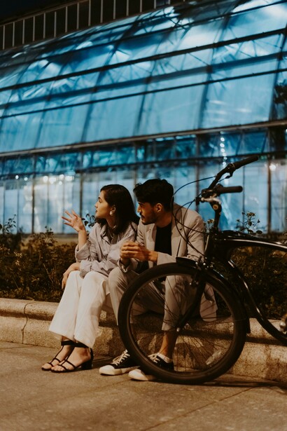 A couple sitting together on the street engaged in a deep conversation