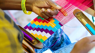In the vibrant setting of Ghana in 2019, a shuttle skillfully maneuvers through the threads, contributing to the intricate artistry of Kente weaving, this snapshot captures the craftsmanship and tradition embedded in the process, where the shuttle becomes a symbol of the meticulous workmanship that brings the renowned Kente cloth to life