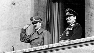 Hitler y Göring saludando desde el balcón de la Cancillería en Berlín tras la anexión de Austria en 1938, proyectando el triunfo de la propaganda nazi