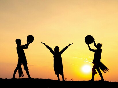 Individuals standing in a line, raising their arms in unison during a beautiful sunset, representing teamwork and collaboration, remindi8ng that building a supportive team helps maintain focus and resilience