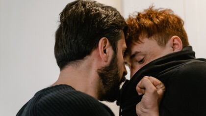 Homem agressivo segura o outro pela blusa