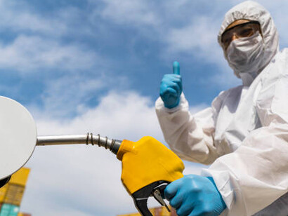 Amid the COVID-19 pandemic and rising energy costs, a worker fills a vehicle at a gas station