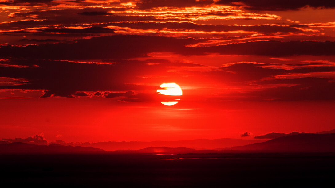 Amanecer teñido de rojo junto al mar