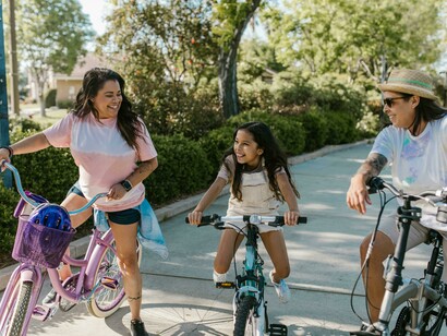 A family rides bicycles through a sustainable city park, reflecting green urban planning