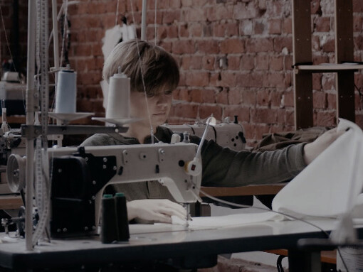 The rhythmic sound of the sewing machine fills the air as dedicated artisans craft pieces that reflect a commitment to sustainability and ethical production