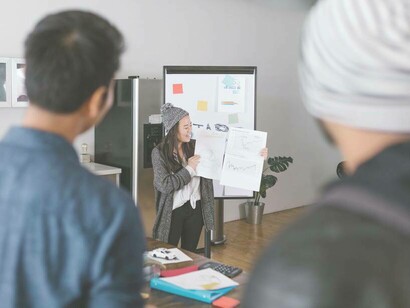 Investors look on and hear the pitch of a young woman's start-up company