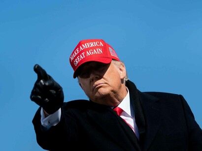 Donald Trump wearing his MAGA cap and pointing to the people that champion him