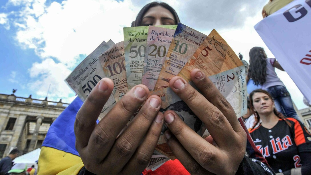 Una venezolana sostiene diferentes billetes de bolívar
