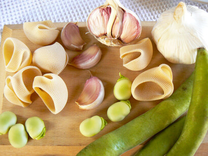 Spicchi d'aglio, fave e conchiglioni