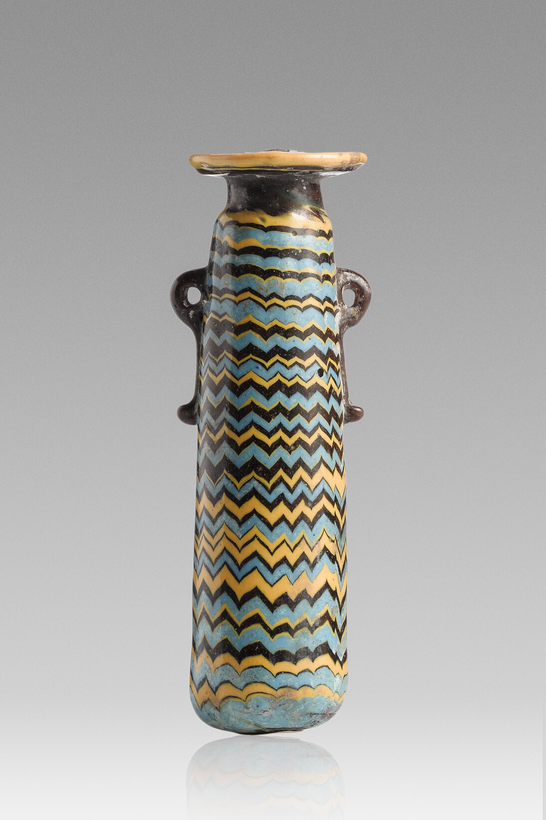 Alabastre - Décor de filets et zigzags jaune et bleu clair, Verre opaque bleu foncé, h. 10,5 ; d. de l’embouchure 2,8 ; d. 3 cm, Découverte : Rhodes
Fin du VIe – Ve siècle av. J.-C. Acquisition Arapidès, 1902, Paris, musée du Louvre, département des AGER
© RMN-Grand Palais (musée du Louvre) / Tony Querrec