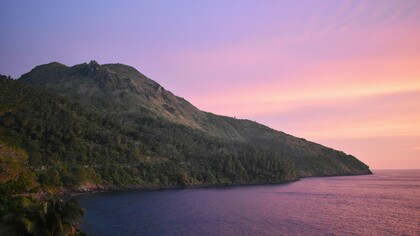 A mountain in Philippines set against the backdrop of a sunset, representing the beauty that awaits those willing to climb to the peak to catch the best views