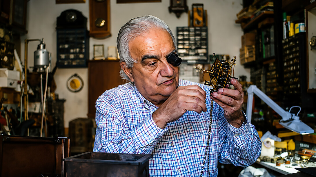 A watchmaker repairing an antique clock mechanism in his workshop