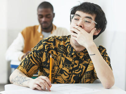 An exhausted student struggles to concentrate during a test