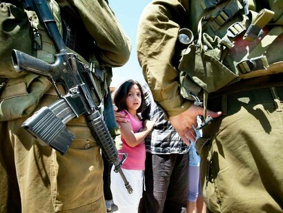 Israeli soldiers standing in front of a frightened young girl and her parent