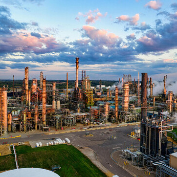 An oil refinery in Rosemount, Minnesota stands under a cloudy sky, symbolizing the industrial footprint driving climate change