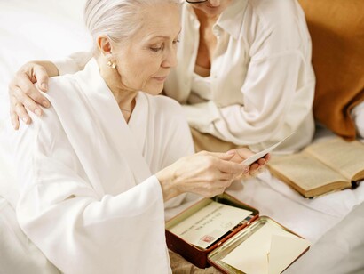 A grandmother reading her old momentos with another woman