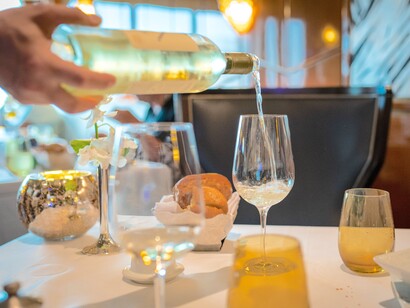 Garçom servindo vinho branco em taça