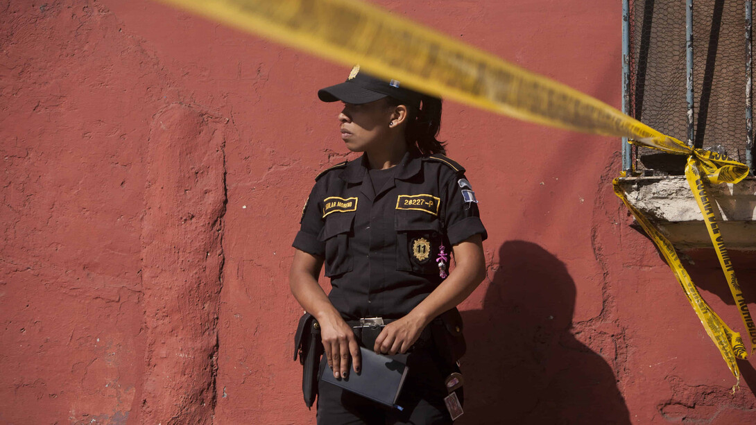 Mujer policía rersguarda una escena de crimen en Guatemala