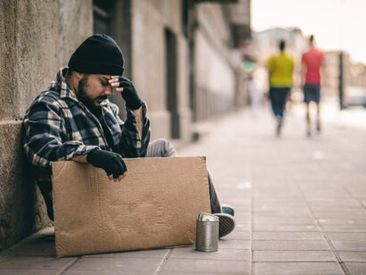 Despairing homeless man on the street, reflecting poverty and health inequality