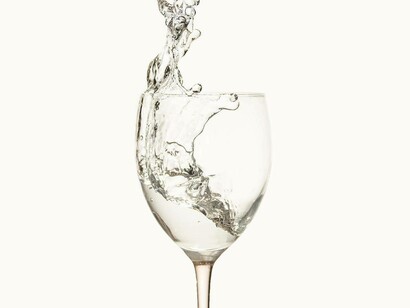 Water being poured into a wine glass for a healthier alternative to what is accustomed