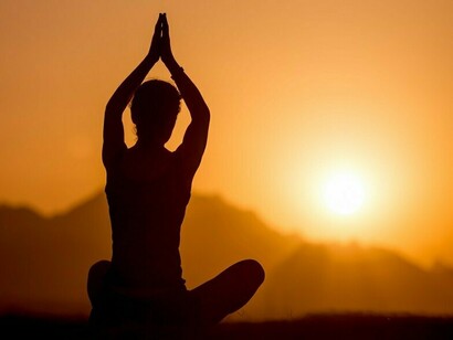 A practitioner embracing the dawn through meditation, representing the cultivation of awareness and inner peace