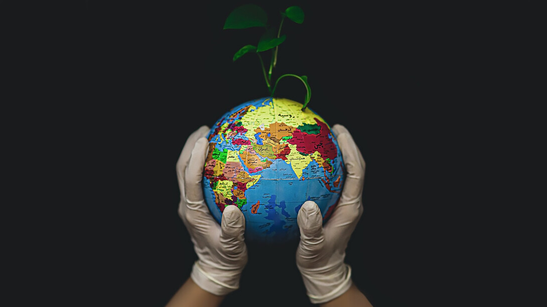 Cradling the Earth in gloved hands, a promising seed begins to sprout