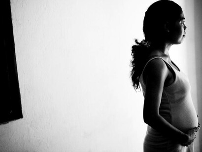 Una mujer embarazada en Timor-Leste mira pensativamente fuera de su ventana. Fotografía Naciones Unidas, 2010  