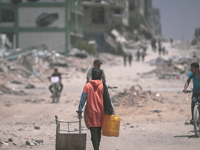Destruction in Gaza in 2024, with buildings reduced to rubble after bombing, as people struggle to survive among the ruins