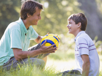 Un padre habla con su hijo mientras juegan