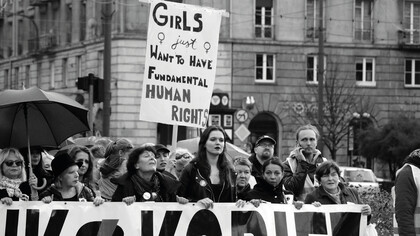 Women march together, proudly holding a banner that reads: "Girls Just Want to Have Fundamental Human Rights