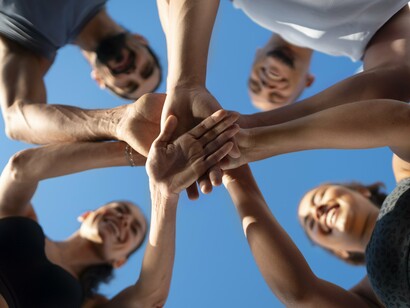 A close-up of interlocked hands symbolizes the unspoken bond between runners—mutual support, shared struggles, and collective determination