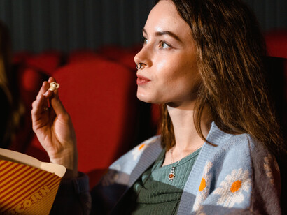 Telescpectadora come pipocas enquanto acompanha atentamente ao filme