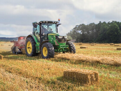 Green farming equipment set against a brown field landscape, Hohenberg-Krusemark, Germany