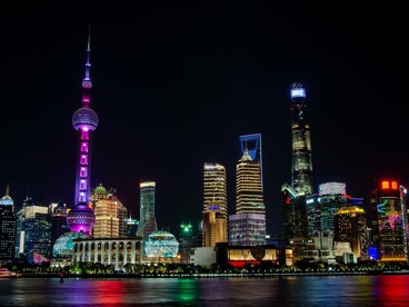 The illuminated skyline featuring the Oriental Pearl Tower in Shanghai, China, representing the country's remarkable transformation into a global economic powerhouse