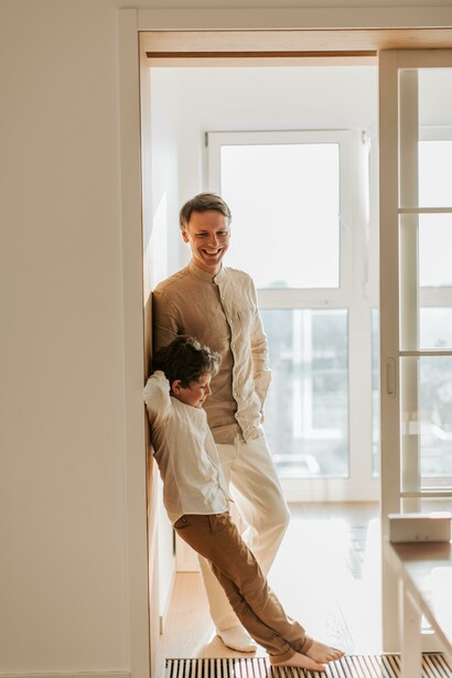 Father and son leaning against a wall