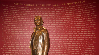 Estatua de Thomas Jefferson frente a un memorial que registra los nombres conocidos de las personas a las que mantuvo como esclavas