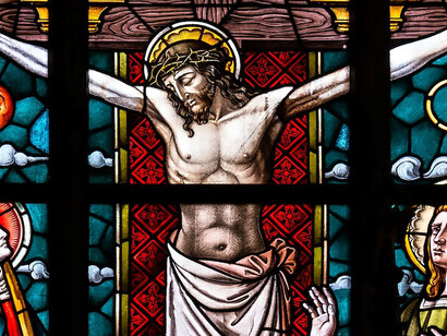 Stained glass artwork portraying Jesus adorns the interior of a church