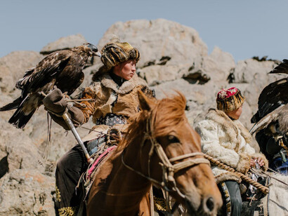 Nomadic people of Mongolia dressed in traditional clothing while riding horses
