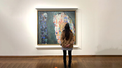 Catalina Rivera standing in front of Gustav Klimt, Life and Death, 1908-1915. Oil Paint on Canvas. Leopold Museum, Vienna