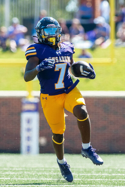 A determined American football player leaps to catch the ball during a high-stakes game