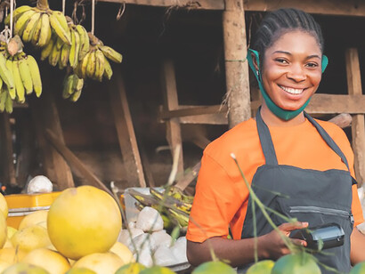 African woman selling fruits at a local market, illustrating economic activity and entrepreneurship in Africa