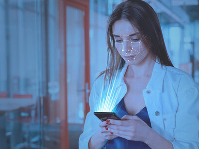 A woman using facial recognition on her smartphone